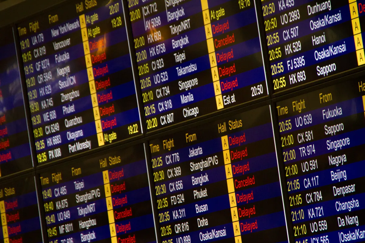 Close-up of an airport flight information board listing departures