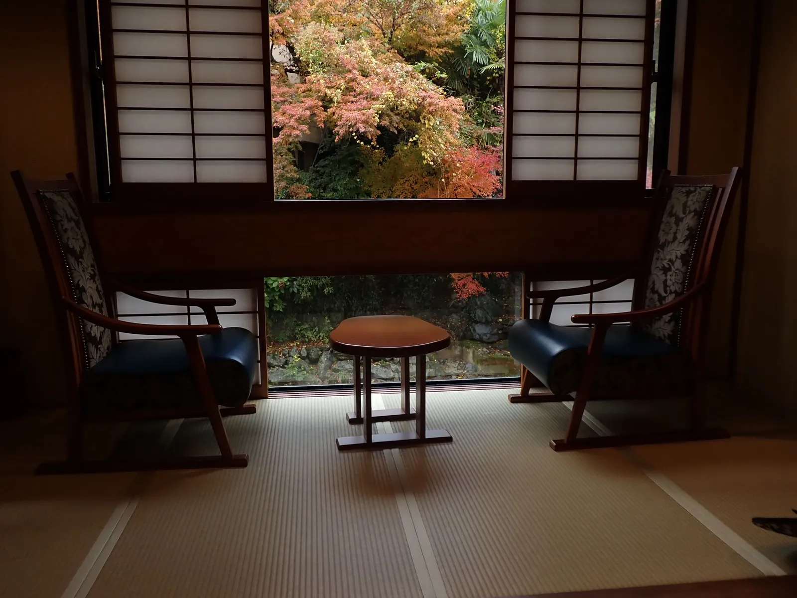 A Japanese room with tatami mats and a garden view through a shoji window
