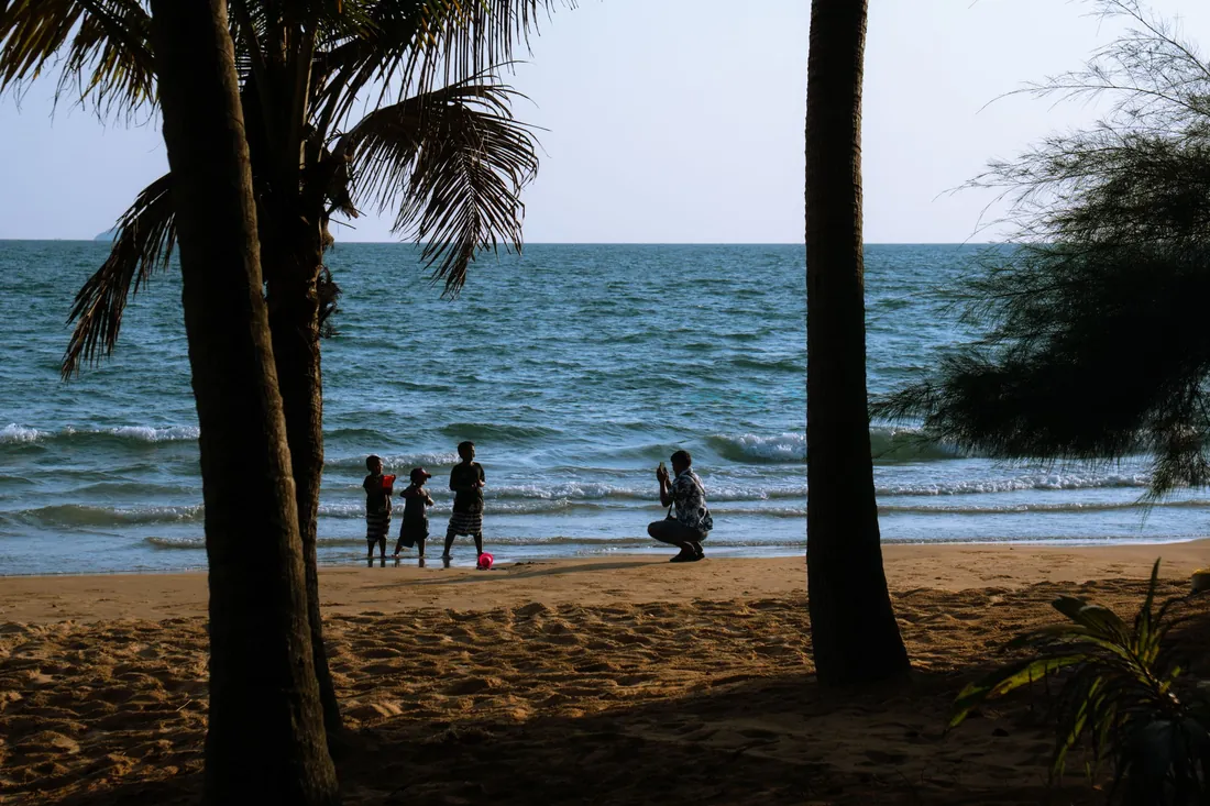A family with children playing on a sunny beach in Chanthaburi, Thailand