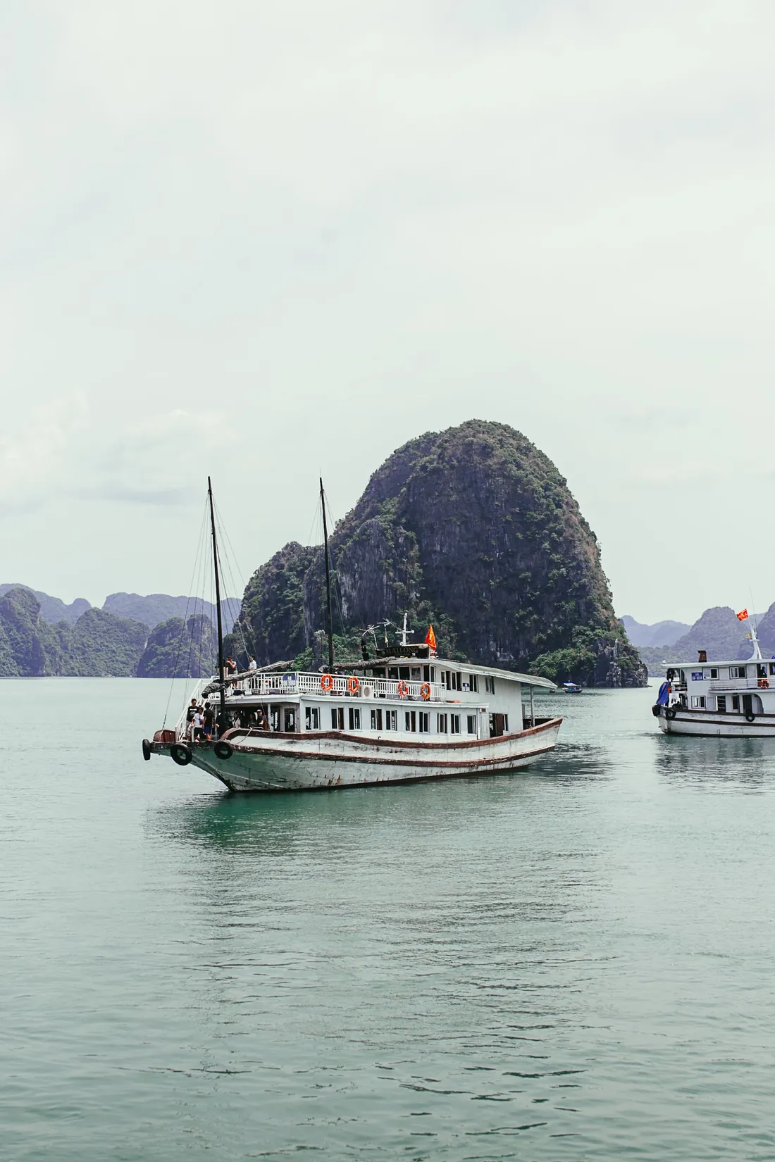 A cruise boat sailing among the limestone islands of Ha Long Bay