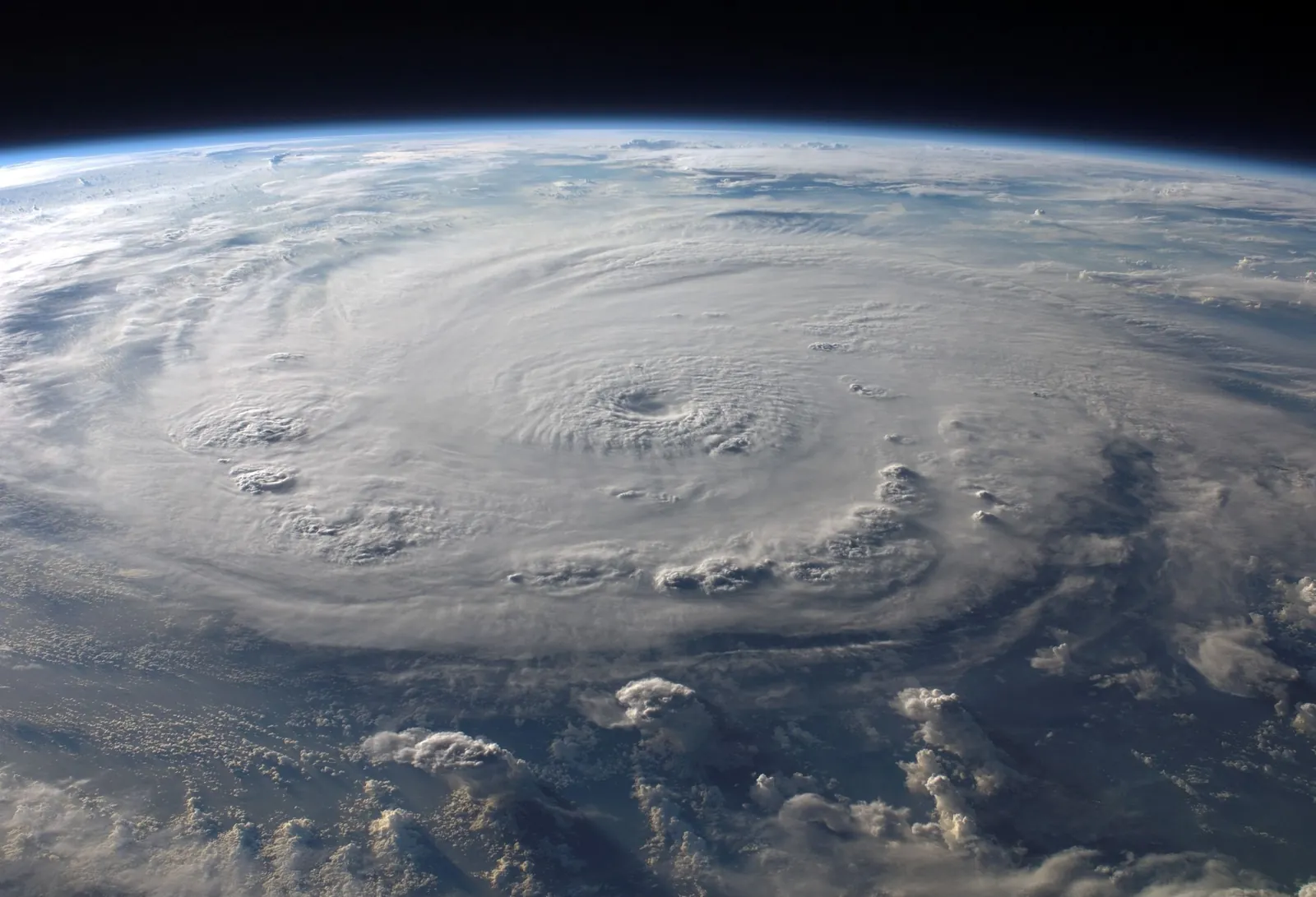 A hurricane seen from space, a white spiral of cloud over a blue ocean