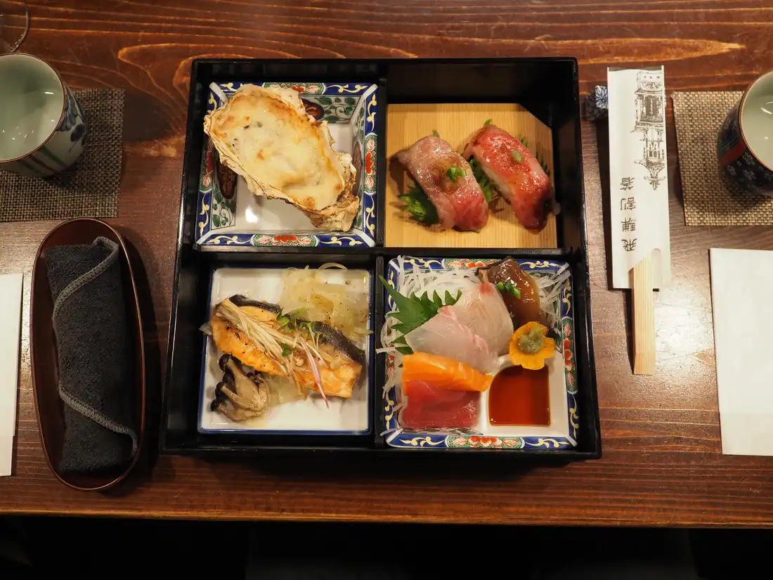 Baked cheese oyster, Hida beef nigiri, salmon, and a sashimi selection
