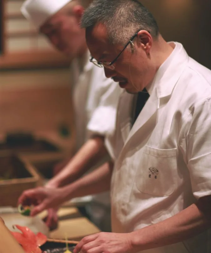 A kaiseki chef plating at the counter